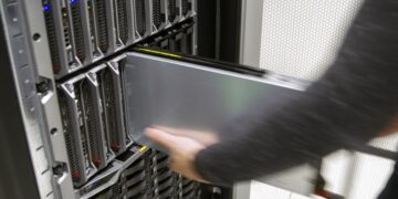 It engineer or consultant works with a blade server in data rack. Efficient and fast working in large enterprise datacenter.