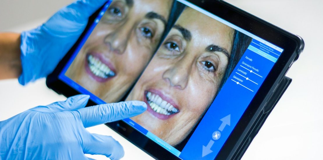 man in blue shirt smiling: Dental Hospital Management Systems