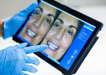 man in blue shirt smiling: Dental Hospital Management Systems